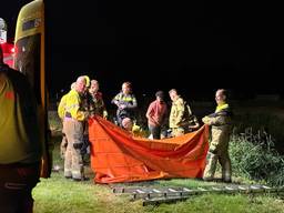 Hulpverleners ontfermen zich over een man die in Sint-Oedenrode vast kwam te zitten in drijfzand (foto: Sander van Gils/SQ Vision).