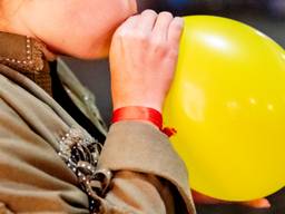Lurken aan een lachgasballon (foto: ANP).