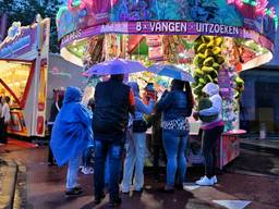 Bezoekers van de kermis in de regen (foto: Toby de Kort).