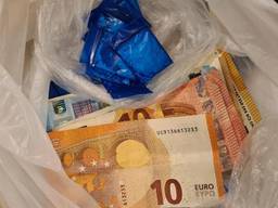 Een deel van de drugs en het geld dat in beslag is genomen (foto: politie Den Bosch Facebook).