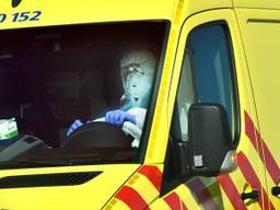 Een volledig tegen het coronavirus ingepakt ambulancechauffeur (archieffoto).