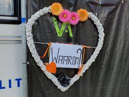 Bloemstukje opgehangen bij de zwarte schermen voor de woning in Etten-Leur.