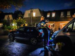Agenten doorzoeken een huis en twee wagens (foto: SQ Vision).