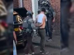 De man wordt door het arrestatieteam uit het huis gehaald.