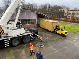 Een zeecontainer wordt geplaatst.