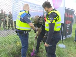 Demonstranten graven gat onder hek bij vliegbasis Volkel