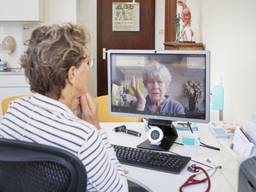 Een huisarts via een beeldverbinding in gesprek met een patiënt (foto: ANP).