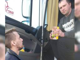 Robin geeft een blik soep uit aan een Oekraïense vrachtwagenchauffeur.