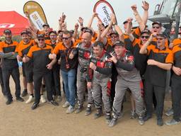 Janus van Kasteren (eerste rij, derde van rechts) viert de zege in de Dakar Rally met zijn team (foto: Ronald Sträter)