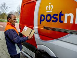 Een postbode van PostNL die brievenbuspakketjes aflevert (foto: ANP). 