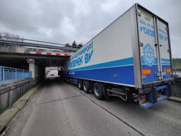 Vrachtwagen vast onder viaduct