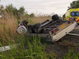 Auto met aanhanger belandt op zijn kant in de sloot