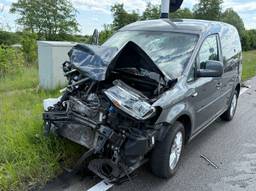 Bestuurder gewond na botsing, weg bezaaid met brokstukken van auto