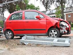 Poort omver gereden bij botsing tussen twee auto's