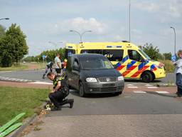 Auto schept fietser op rotonde