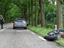 Motorrijder haalt rij auto's in en botst achterop