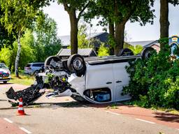 Busje belandt ondersteboven na ongeluk en eindigt tegen boom