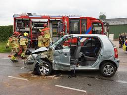 Vrouw bekneld in auto na botsing met vrachtwagen