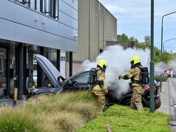 Elektrische auto vliegt in brand op parkeerplaats, bedrijf ontruimd