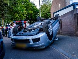 Automobilist botst tegen geparkeerde auto en slaat over de kop