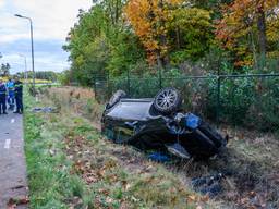 Auto botst op lantaarnpaal en belandt op zijn kop in de sloot