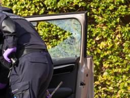 Politie bij een beschadigde auto na een schietpartij in de Klaverhof (foto: Harrie Grijseels/Persbureau Heitink).