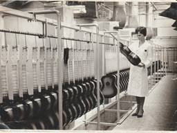 Een medewerkster controleert gitaren in de Egmond Gitarenfabriek in Best (foto: privécollectie familie Egmond).