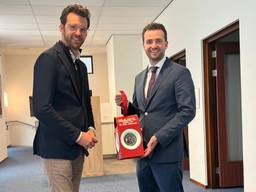 De burgemeester van Katwijk (links) krijgt de lantaarn van burgemeester Heldens.