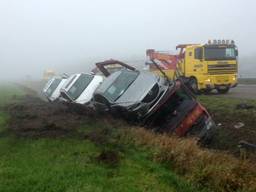 Vrachtwagen met auto's in de sloot (foto: Martien van Dam/SQ Vision)