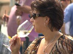 Met 'n glas witte wijn in de hand genieten van de polosport tijdens Pinkster Polo in Waalre