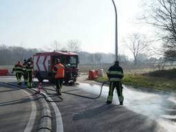 De brandweer maakt het wegdek schoon. (Foto: Martijn van Bijnen/FPMB).