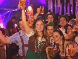 Oktoberfest-vierders in lederhosen en dirndl