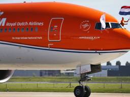 Ferry Weertman houdt de vlag vast bij aankomst op Schiphol (foto: ANP)