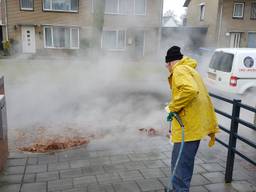 Willy Looymans spuit de stoep schoon bij De Vonder. (Foto: Noel van Hooft)