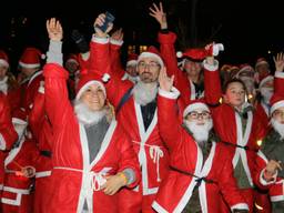 De kerstmannen rennen onder begeleiding van muziek door Breda.
