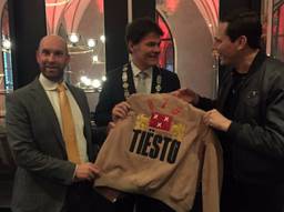 Een glunderende DJ Tiësto laat z'n erepenning zien 