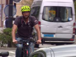 Het is een apart straatbeeld: een fietser tussen de auto's en vrachtwagens.