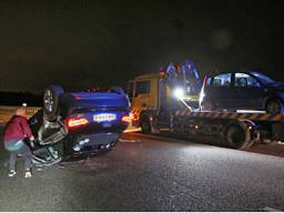 Een auto kwam op zijn dak terecht. (Foto: Remco de Ruijter)