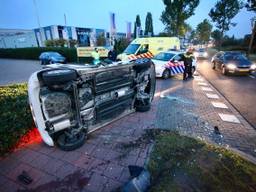 Een auto komt bij een botsing op z'n kant terecht. (Foto: Jeroen Stuve)