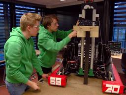 Studenten monteren de laatste onderdelen op hun zelfgebouwde robot