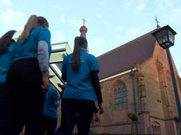 Kinderen dragen een kruis naar de kerk