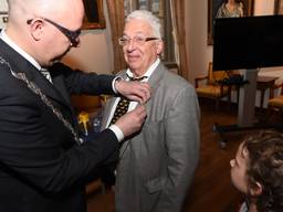 Johan Henskens krijgt de onderscheiding opgespeld (foto: Henk van Esch).