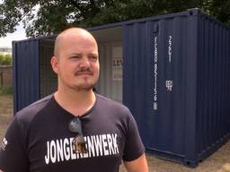 Initiatiefnemer Vic van Dijk naast de hangcontainer