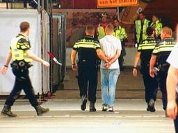 Eén van de verdachten wordt afgevoerd (foto: Martijn van de Wouw).
