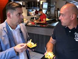 Verslaggever Ronald Sträter eet samen met John Karelse een frietje met.