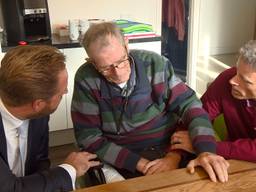 Minister Hugo de Jonge praat met gasten en hun familie in de woonkamer van het hospice.