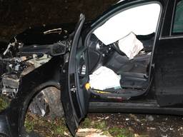 De zwaar beschadigde auto nadat de automobiliste verschillende bomen op de Dorpenweg heeft geraakt (Foto: Gabor Heeres)