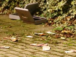 De overvallers lieten twee geldlades en wat briefgeld achter op de Karnemelkstraat. (Foto: Danny van Schijndel)