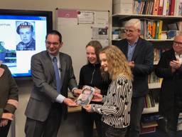 Burgemeester Adriaansen geeft het boek Spion van Oranje aan leerlingen van groep 8