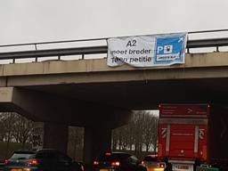 De VVD hangt spandoeken over de A2 om aandacht te vragen voor het fileleed. FOTO: Merel de Leuw